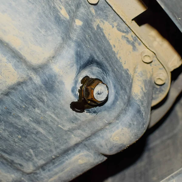 从发动机上排出的旧油通过排水管塞 在汽车发动机中更换机油 — 图库照片