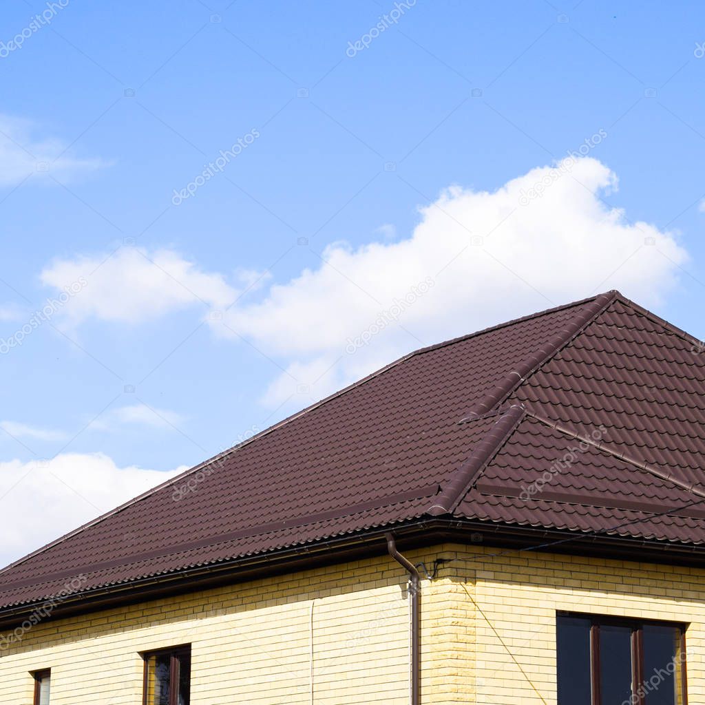 Decorative metal tile on a roof. Types of a roof of roofs. Decorative metal on the roof of the house.