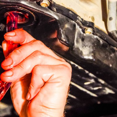 Otomatik şanzıman yağ değişimi. Hortum aracılığıyla petrol dolum. Araba bakım istasyonu. Kırmızı dişli yağı. Araba tamircisi yağı eller.