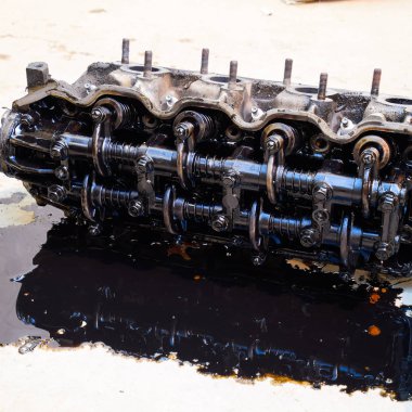 Silindir bloğunun başı. Silindir bloğunun başı tamir için motordan çıkarıldı. Motor yağının parçaları. Araç motoru tamiri serviste..