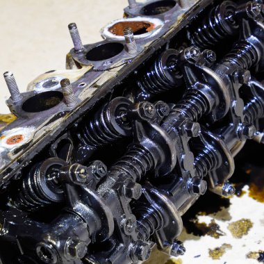 Silindir bloğunun başı. Silindir bloğunun başı tamir için motordan çıkarıldı. Motor yağının parçaları. Araç motoru tamiri serviste..
