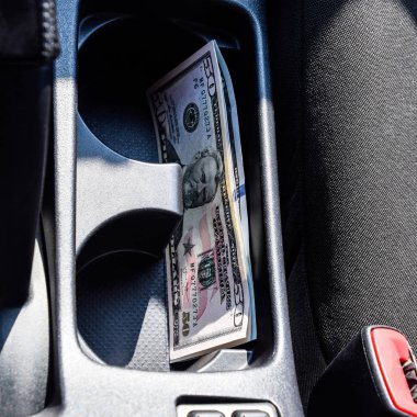 Birkaç banknot Amerikan Doları arabanın Merkezi Konsol niş içinde yalan. Para arabada.