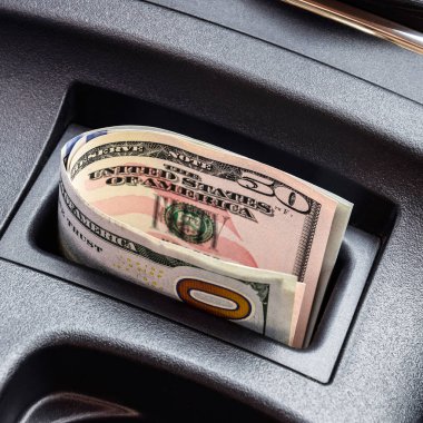Birkaç banknot Amerikan Doları arabanın Merkezi Konsol niş içinde yalan. Para arabada.