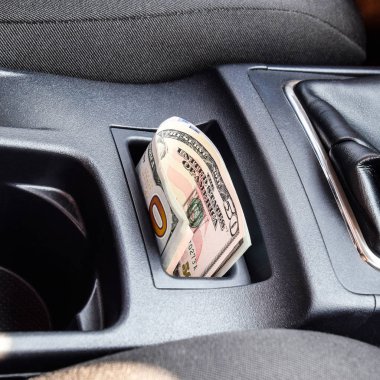Birkaç banknot Amerikan Doları arabanın Merkezi Konsol niş içinde yalan. Para arabada.
