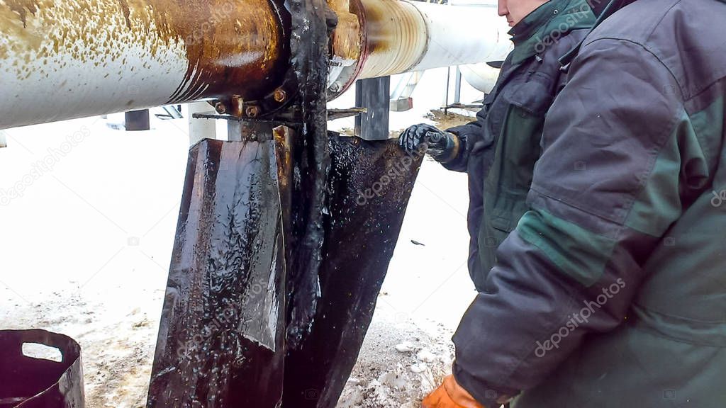 Liquidation of the oil spill. Locksmiths are engaged in eliminating oil leakage and repairing equipment. Workers liquidate the oil spill
