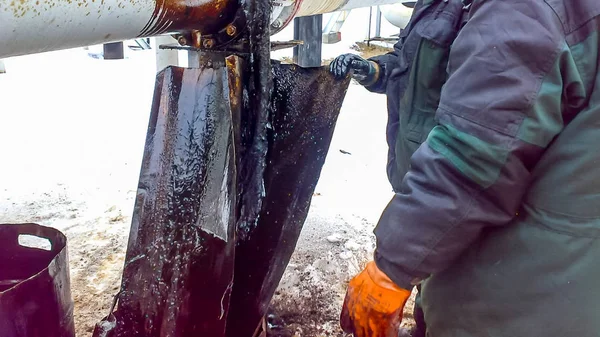 Liquidation of the oil spill. Locksmiths are engaged in eliminating oil leakage and repairing equipment. Workers liquidate the oil spill