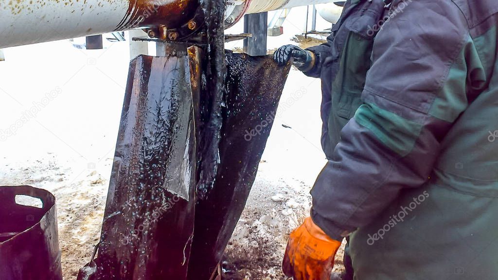 Liquidation of the oil spill. Locksmiths are engaged in eliminating oil leakage and repairing equipment. Workers liquidate the oil spill