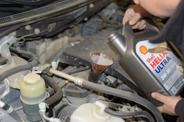 Otomobilin motor yağ değişimi. Huni yağ doldurma. Araba bakım istasyonu.