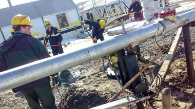Petrol sızıntısı tasfiye. Çilingirler yağ kaçağı ortadan kaldırarak ve donatım tamiri yapan. İşçiler petrol sızıntısı tasfiye.