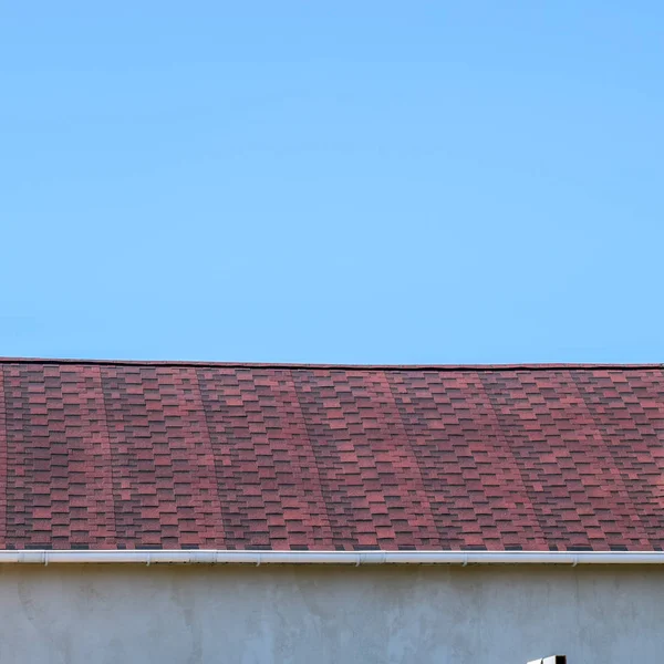 Dak van multi-gekleurde bitumineuze gordelroos. Gedessineerde bitumen shingles. Bitumineuze donkerrood dak. — Stockfoto