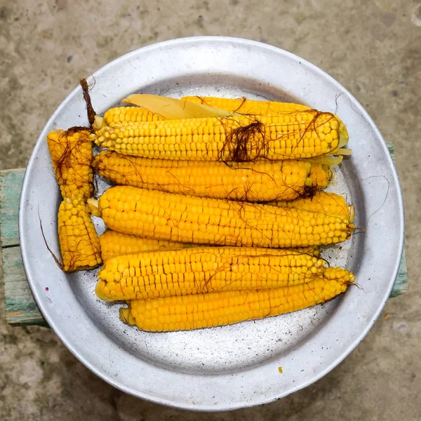 Вареная кукуруза на алюминиевом подносе. Желтая вареная молодая кукуруза, полезная и вкусная еда — стоковое фото