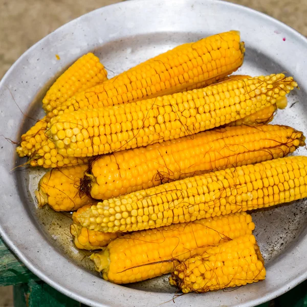 Вареная кукуруза на алюминиевом подносе. Желтая вареная молодая кукуруза, полезная и вкусная еда — стоковое фото