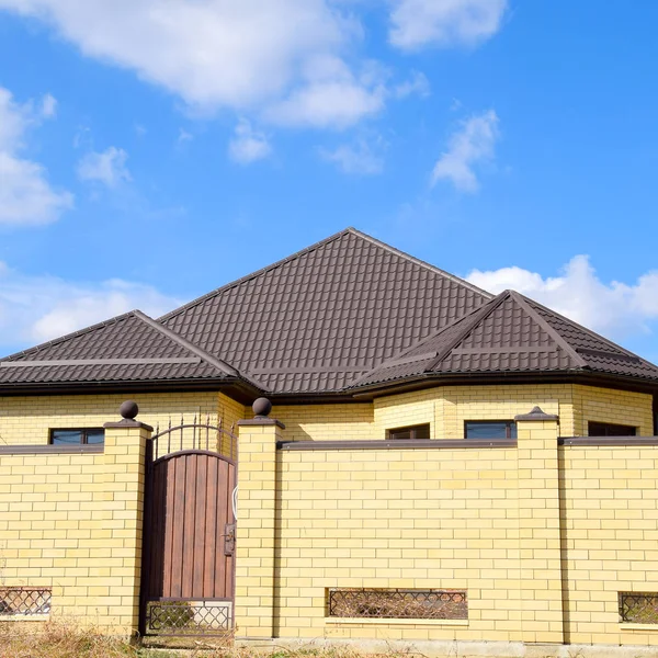 Metallo decorativo sul tetto di una casa di mattoni. Recinzione in metallo ondulato . — Foto Stock