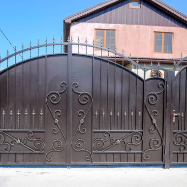 bir çit ve kapıları olan ev. Görünümü bir ev ve yeni bir İnşaatlı çit