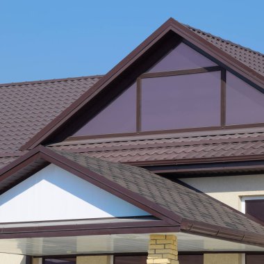 Plastik pencere ve oluklu levha kahverengi bir çatı ile ev