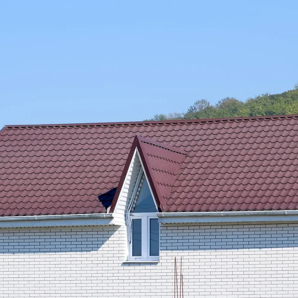 Huis met kunststof ramen en een bruin dak van golfplaten — Stockfoto