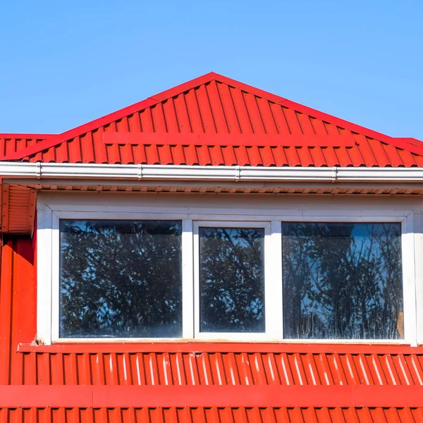 Haus mit Kunststofffenstern und rotem Dach aus Wellblech — Stockfoto