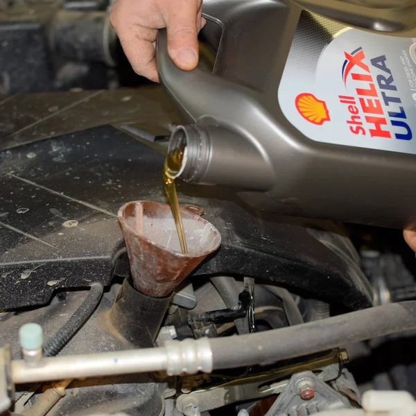 在汽车的发动机换油。填充油漏斗形。汽车维修站. — 图库照片