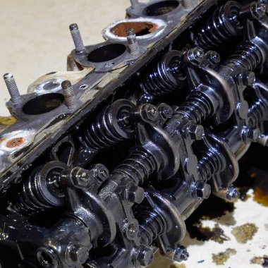 Silindir bloğunun başı. Silindir bloğunun başı tamir için motordan çıkarıldı. Motor yağının parçaları. Araç motoru tamiri serviste.