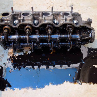 Silindir bloğunun başı. Silindir bloğunun başı tamir için motordan çıkarıldı. Motor yağının parçaları. Araç motoru tamiri serviste.