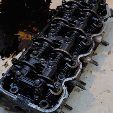 Silindir bloğunun başı. Silindir bloğunun başı tamir için motordan çıkarıldı. Motor yağının parçaları. Araç motoru tamiri serviste.