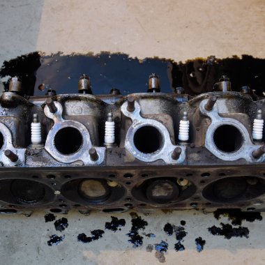 Silindir bloğunun başı. Silindir bloğunun başı tamir için motordan çıkarıldı. Motor yağının parçaları. Araç motoru tamiri serviste.