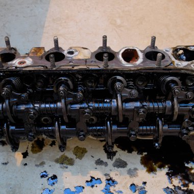 Silindir bloğunun başı. Silindir bloğunun başı tamir için motordan çıkarıldı. Motor yağının parçaları. Araç motoru tamiri serviste.