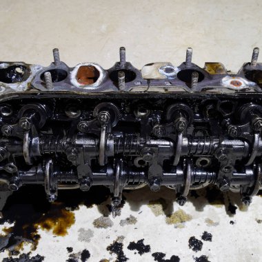 Silindir bloğunun başı. Silindir bloğunun başı tamir için motordan çıkarıldı. Motor yağının parçaları. Araç motoru tamiri serviste.