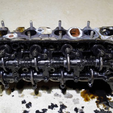 Silindir bloğunun başı. Silindir bloğunun başı tamir için motordan çıkarıldı. Motor yağının parçaları. Araç motoru tamiri serviste.