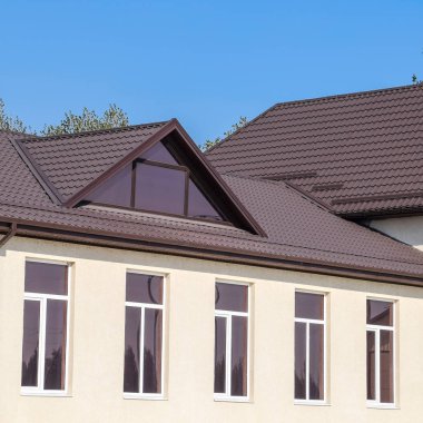 Plastik pencere ve oluklu levha çatısı olan ev. Çatı metal profil dalgalı şeklin üzerinde plastik penceresi olan ev