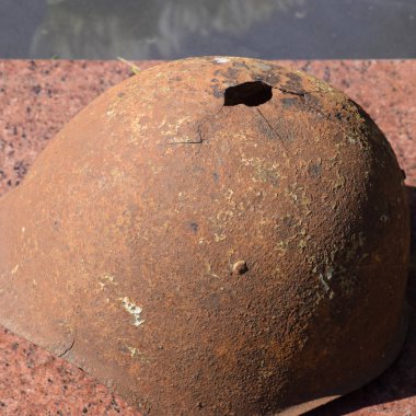 Eski askerin koruyucu kask. Kask ile bir delik. Anıtın üzerinde çelik kask