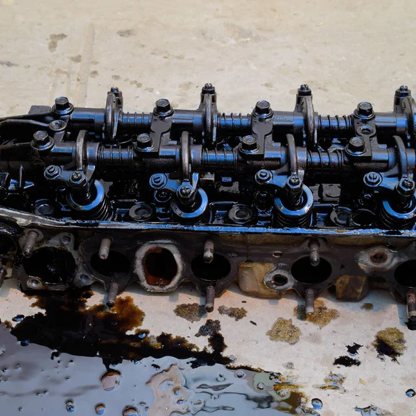 Silindir bloğunun başı. Silindir bloğunun başı tamir için motordan çıkarıldı. Motor yağının parçaları. Araç motoru tamiri serviste.