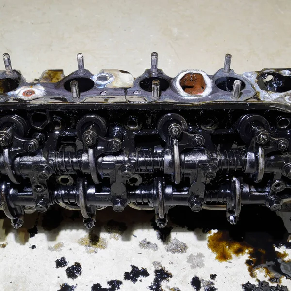 Silindir bloğunun başı. Silindir bloğunun başı tamir için motordan çıkarıldı. Motor yağının parçaları. Araç motoru tamiri serviste.