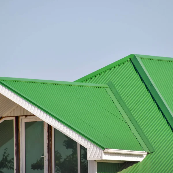 Das Haus mit Kunststofffenstern und einem begrünten Dach aus Wellblech — Stockfoto