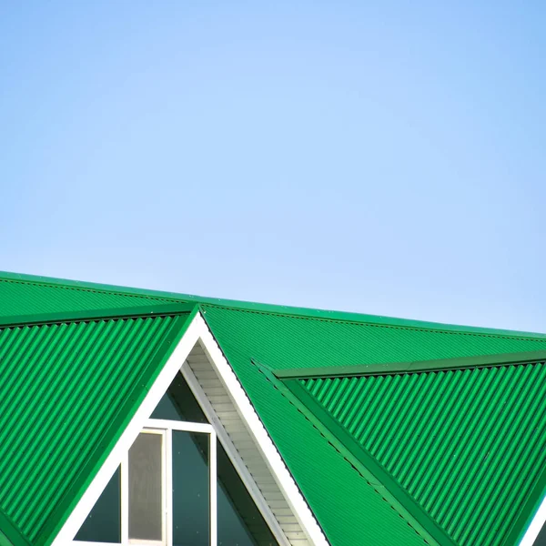 La casa con finestre di plastica e un tetto verde di lamiera ondulata — Foto Stock