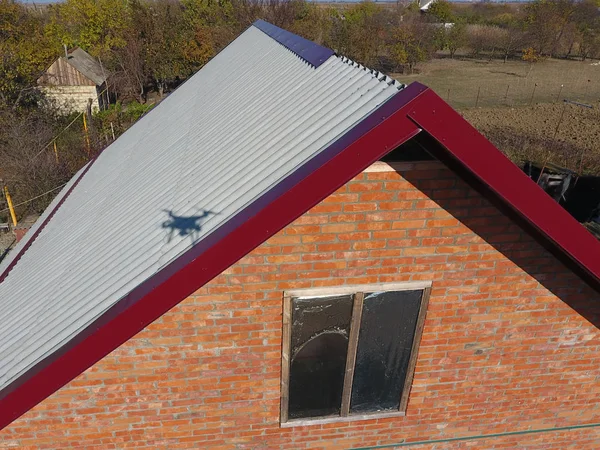 Stavba střechy domu, rohy brusle z červeného kovového profilu. — Stock fotografie