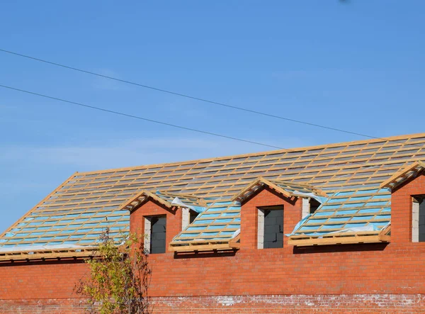 Bau des Daches eines neuen Hauses. Holzstäbe und Dampfsperre — Stockfoto