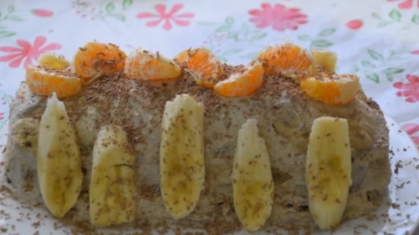 Tårta med banan och mandariner, beströs med choklad. — Stockvideo