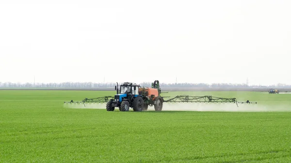 Trator com um dispositivo de pulverização para fertilizantes finamente dispersos . — Fotografia de Stock