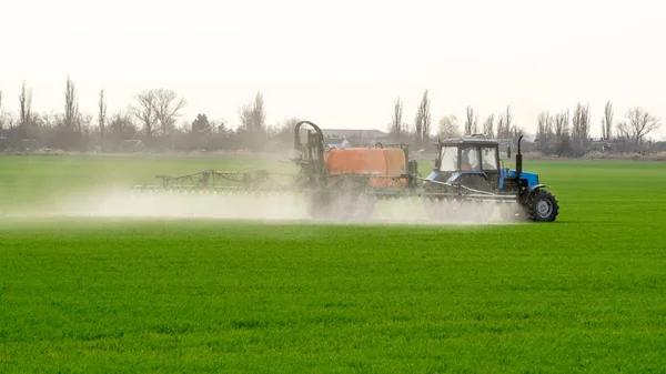Traktör ince dağınık gübre için bir sprey cihazı ile.