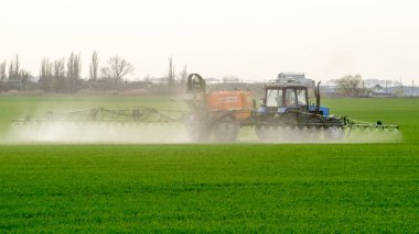 Traktör ince dağınık gübre için bir sprey cihazı ile.