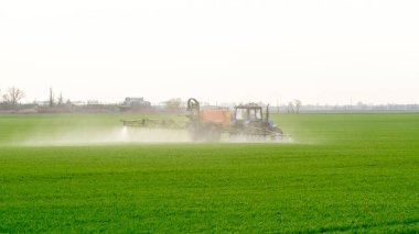 Traktör ince dağınık gübre için bir sprey cihazı ile.