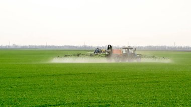 Traktör ince dağınık gübre için bir sprey cihazı ile.