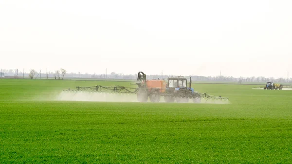 Traktor dengan perangkat semprot untuk pupuk halus yang tersebar . — Stok Foto