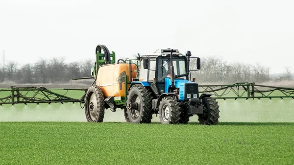 Trator com um dispositivo de pulverização para fertilizantes finamente dispersos . — Fotografia de Stock