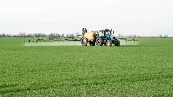 Trekker met een spray apparaat voor fijn verspreide meststof. — Stockfoto