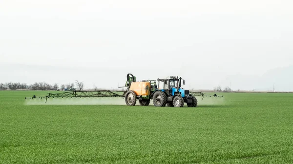 Trekker met een spray apparaat voor fijn verspreide meststof. — Stockfoto