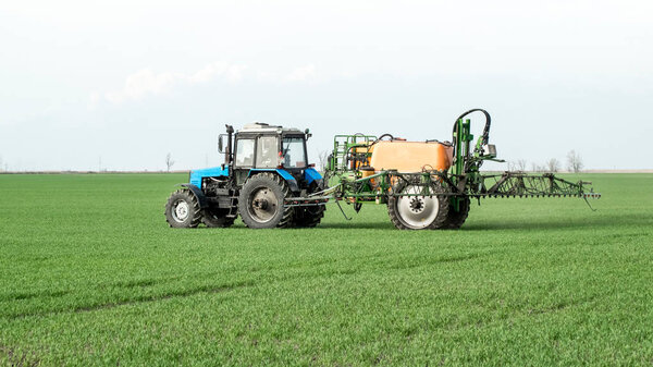 Tractor with a spray device for finely dispersed fertilizer.