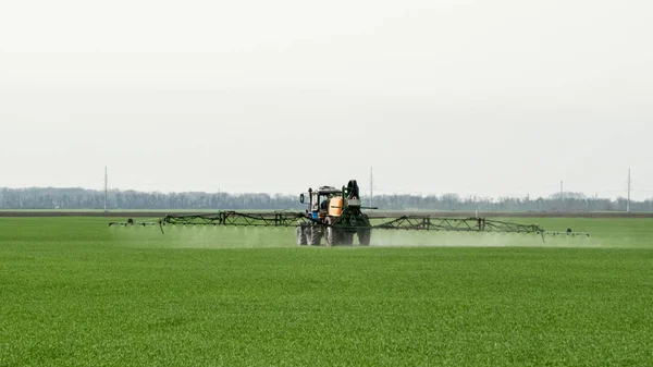 Tractor with a spray device for finely dispersed fertilizer.