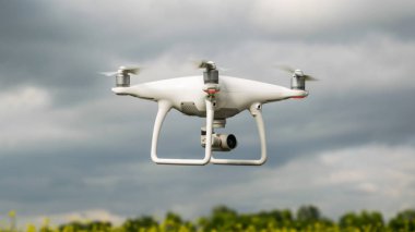 Çiçekli tecavüz alanında beyaz drone.